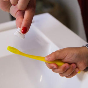 Une brosse à dents jaune pour les enfants, en action.